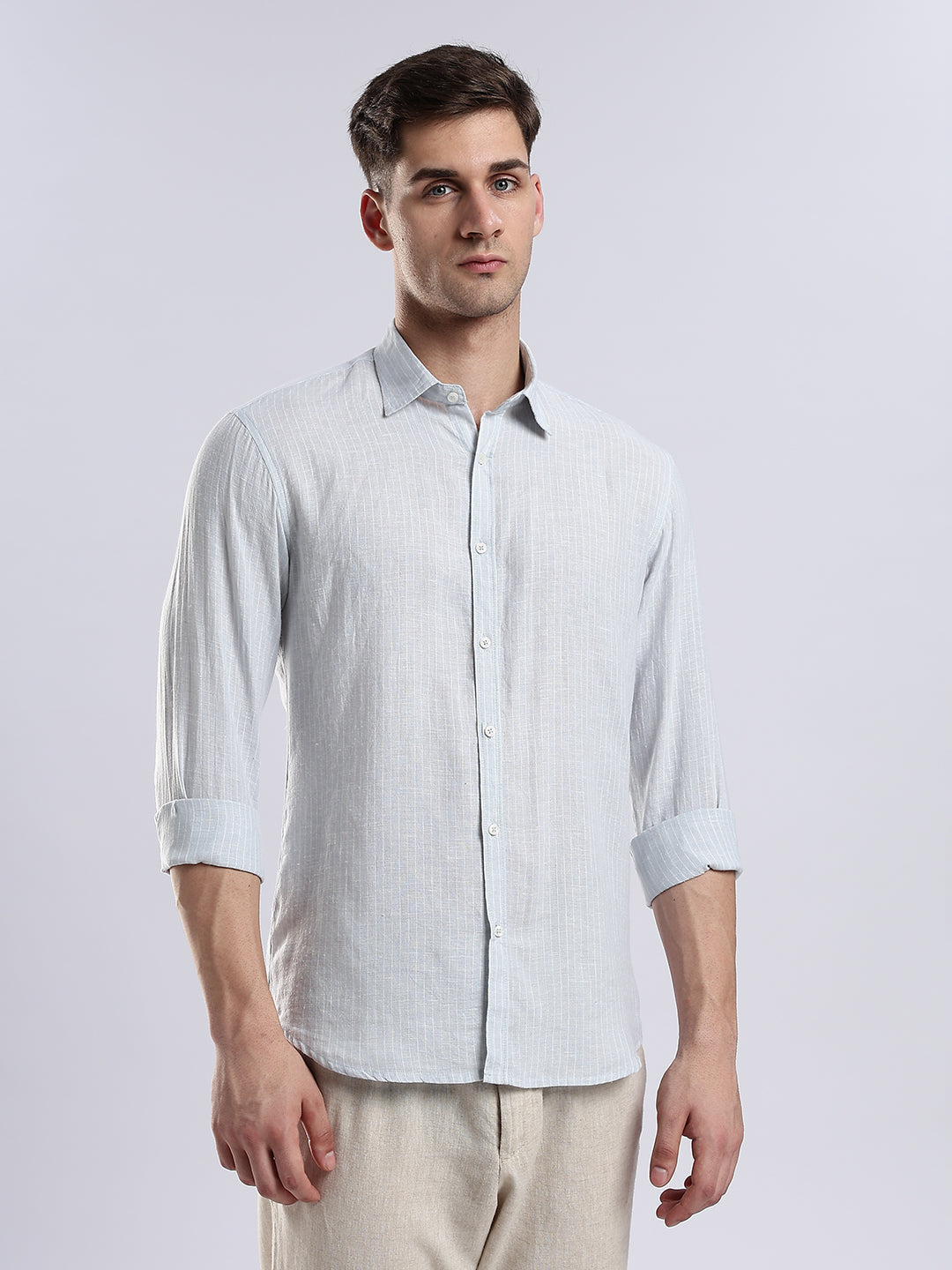 Minimalist light blue long-sleeve linen shirt paired with neutral chinos.