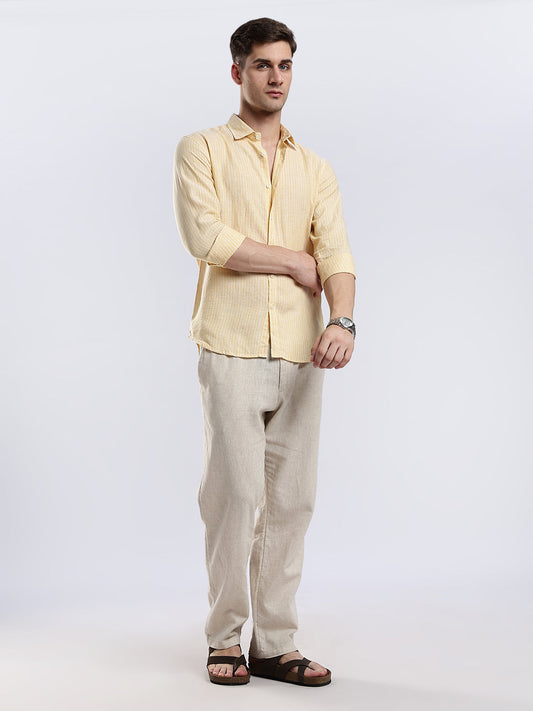 Close-up of a light yellow textured button-down shirt showcasing the breathable linen fabric weave.