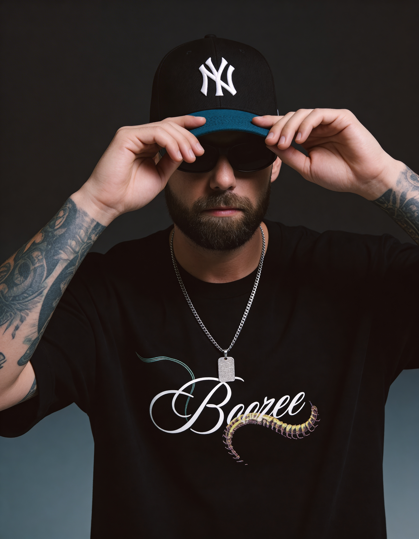 Man wearing a black cap with a logo, sunglasses, and a black t-shirt with 'Boozee' design.
