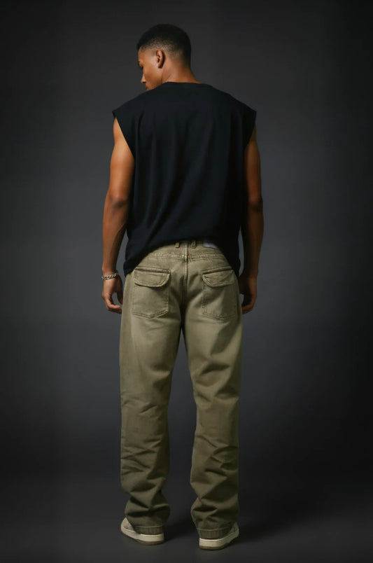 Man wearing a black sleeveless shirt and beige pants against a dark background