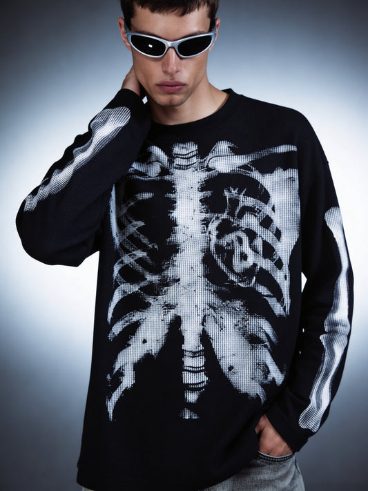 Person wearing a black long-sleeve shirt with a white skeleton design on a gray background