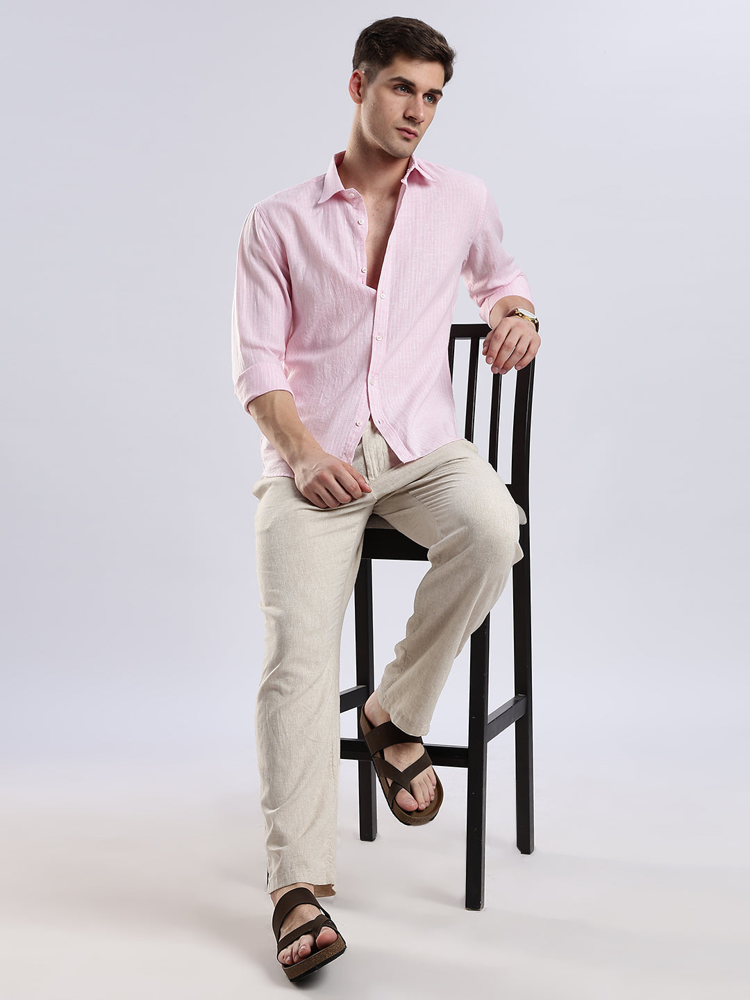 Men's casual pink linen shirt styled with rolled-up sleeves for a relaxed summer aesthetic.
