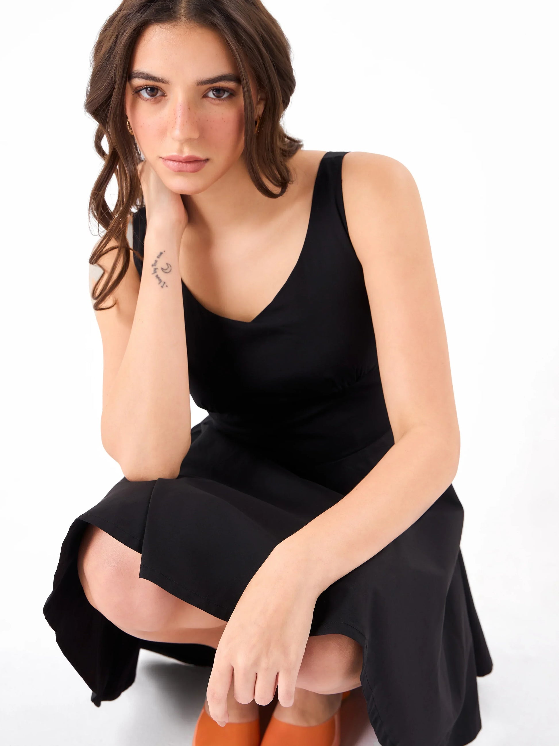 Female model wearing a casual V-neck black sleeveless dress from Stylera