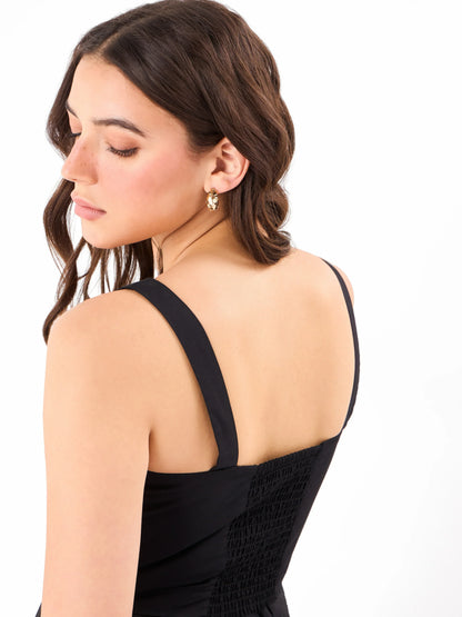 Female model wearing a casual black sleeveless dress from Stylera, showcasing the backside