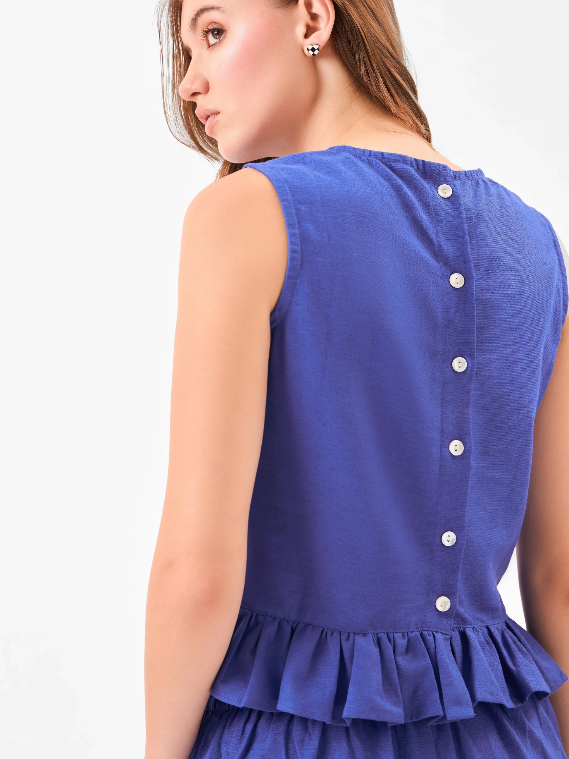 Female model wearing a blue outfit includes fril button down top from back & pants from Stylera