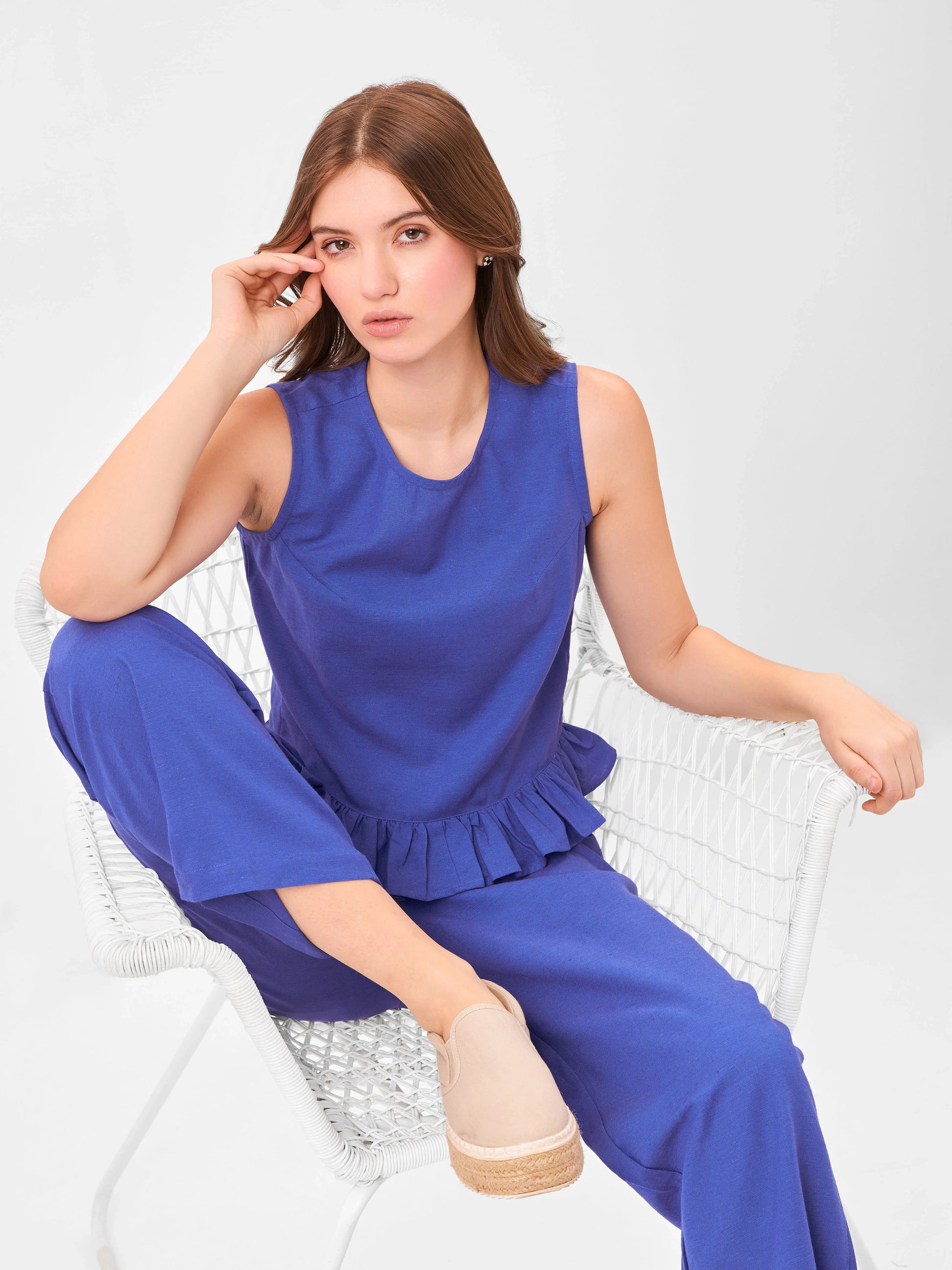 Female model wearing a blue outfit from Stylera, styling on chair