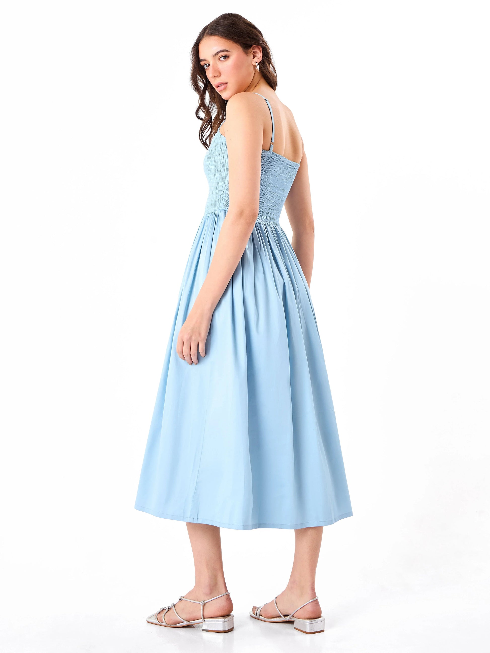 Female model wearing a light blue dress from Stylera, showcasing backside