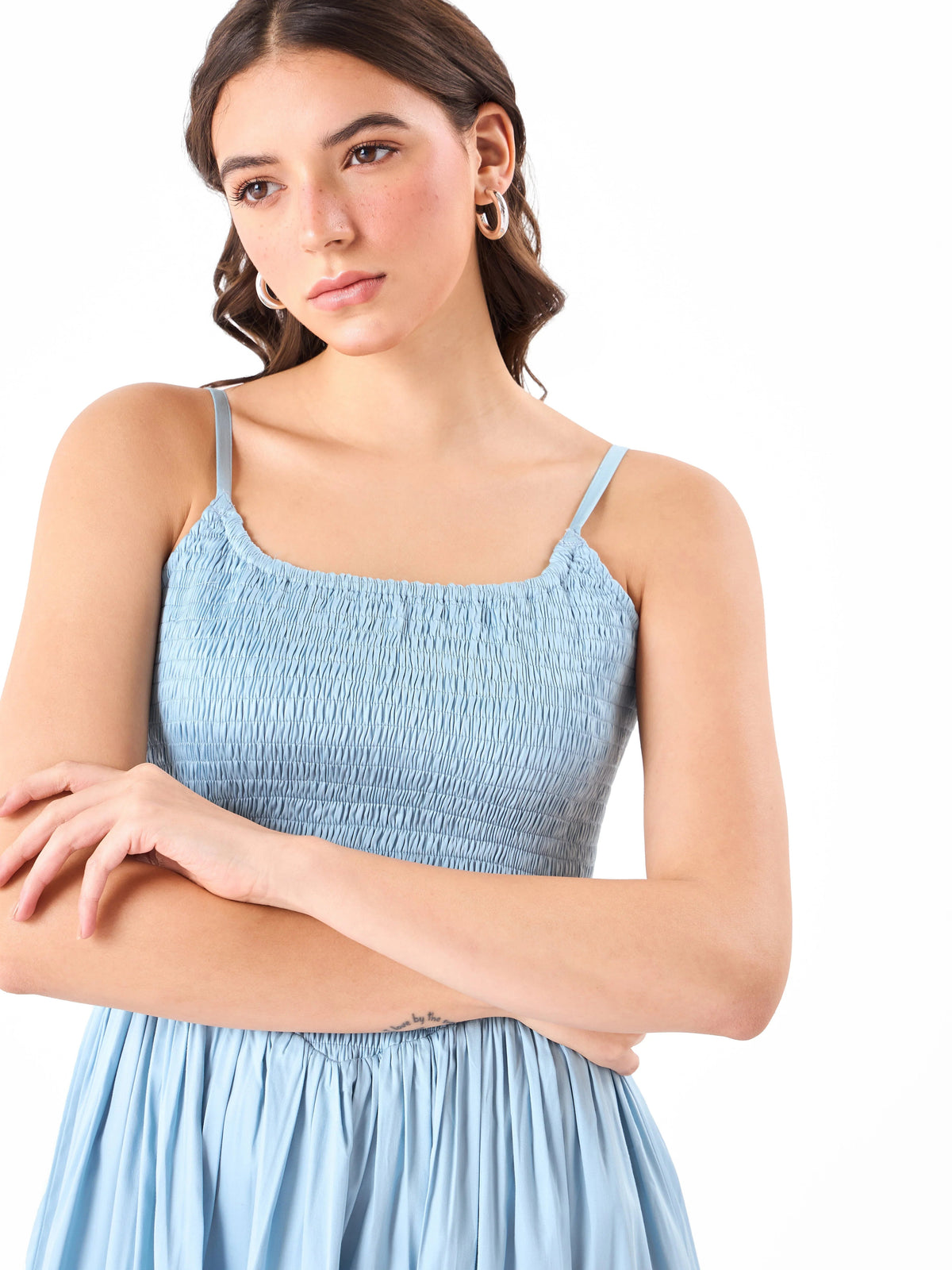 Female model wearing a light blue smocked dress from Stylera