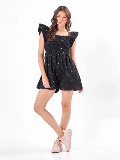 Female model wearing a embroidered black romper from Stylera