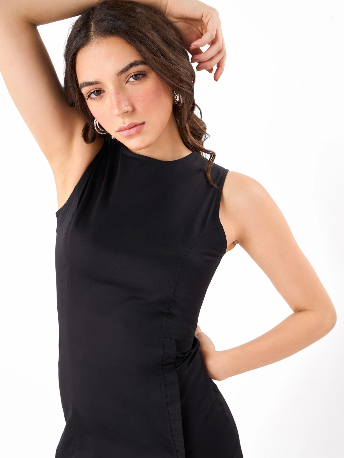 Female model wearing a solid pattern black sleeveless dress from Stylera