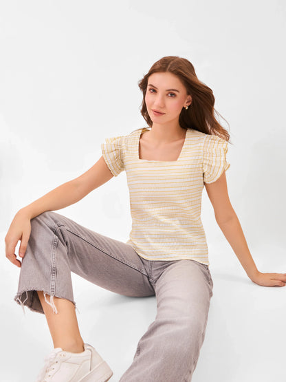 Female model wearing a yellow and white striped comfortable top with ruffled sleeves from Stylera