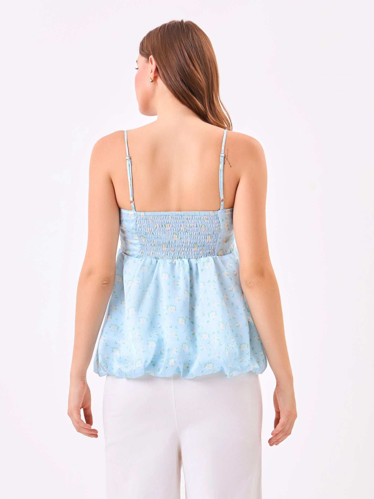 Female model wearing a light blue floral top from Stylera, showcasing backside