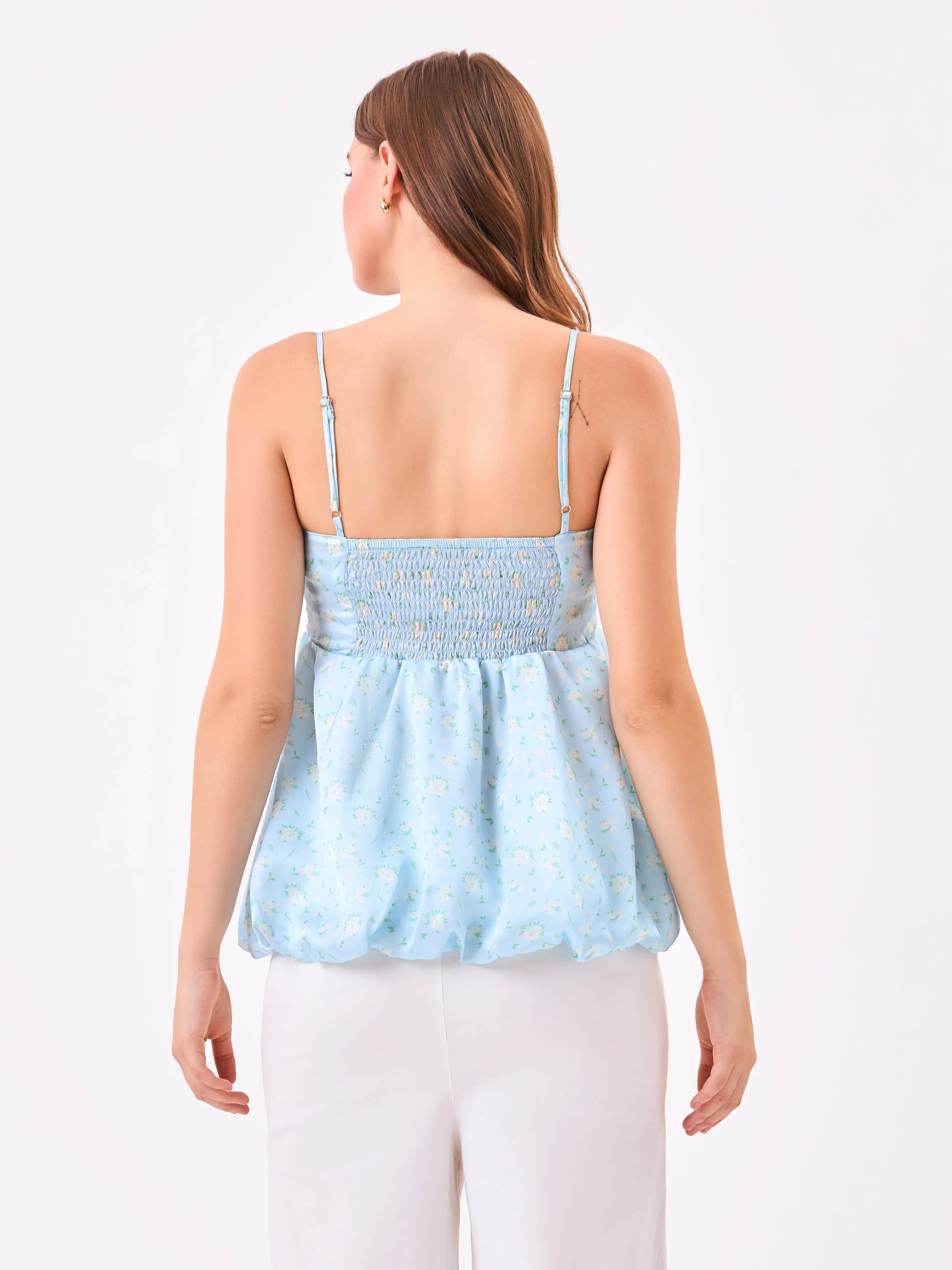 Female model wearing a light blue floral top from Stylera, showcasing backside