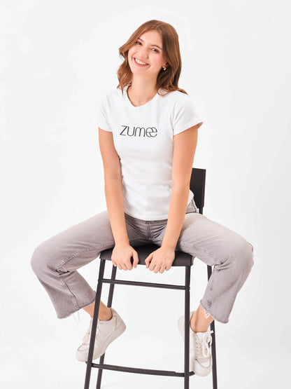 Female model wearing a white t-shirt with 'Zume' logo from Stylera pairing with a grey denim