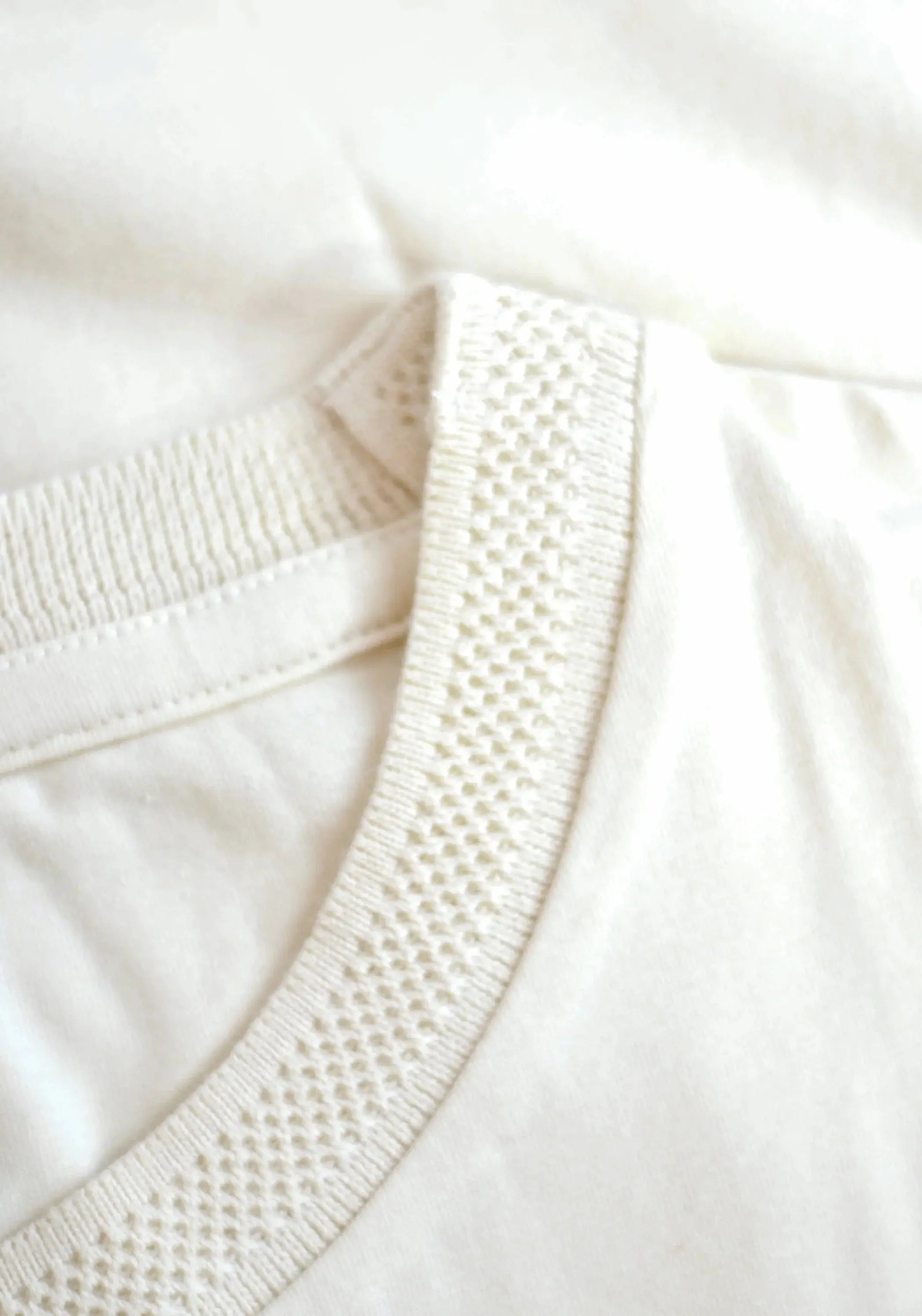 Close-up of Stylera men's trendy cream t-shirt collar with textured ribbed detail