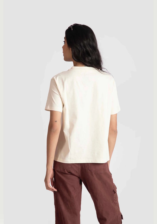 Back view of woman wearing motivational quote off white t-shirt for women paired with brown pants