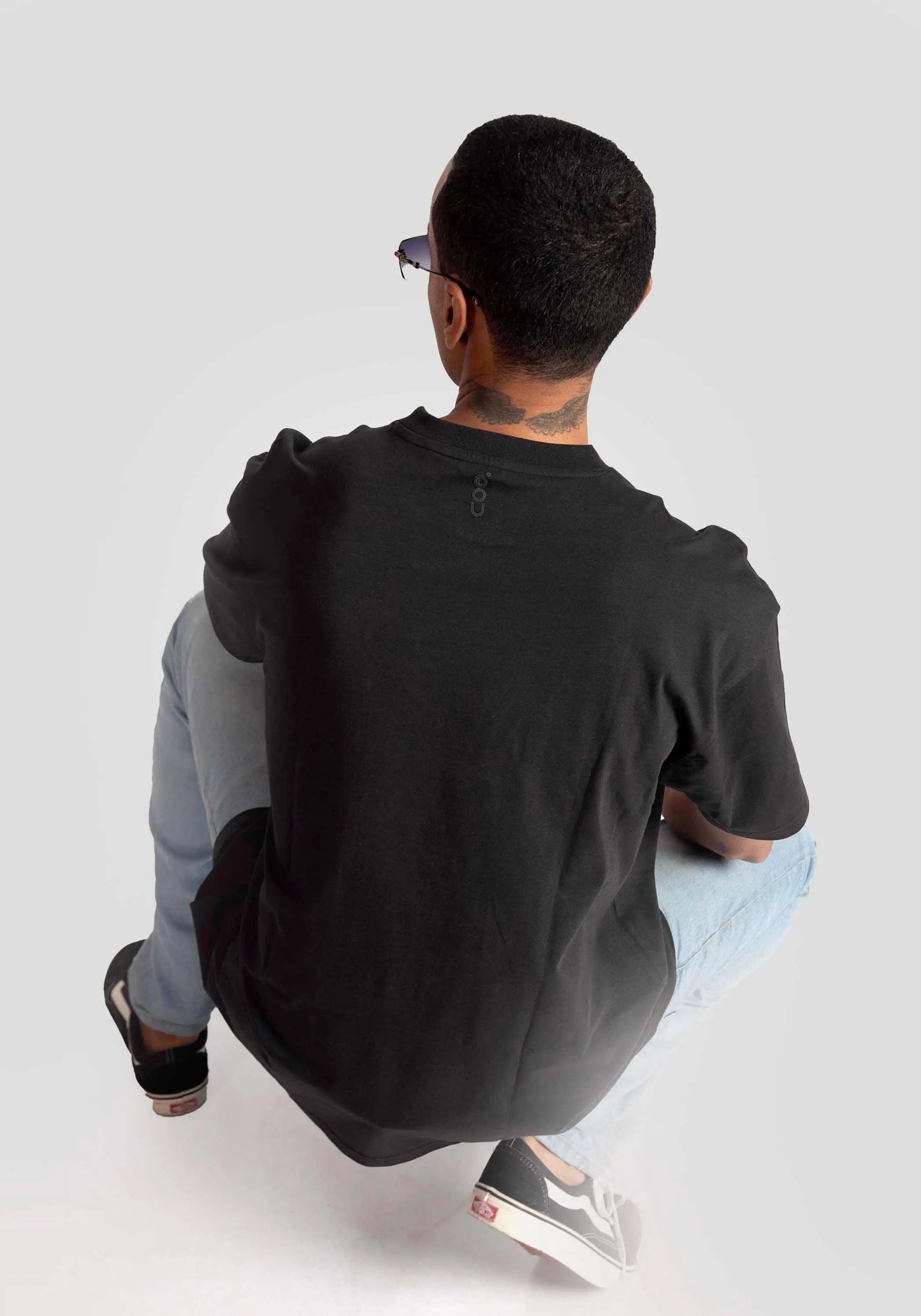 Man wearing black oversized fashion t-shirt for men from Stylera paired with light jeans and sneakers