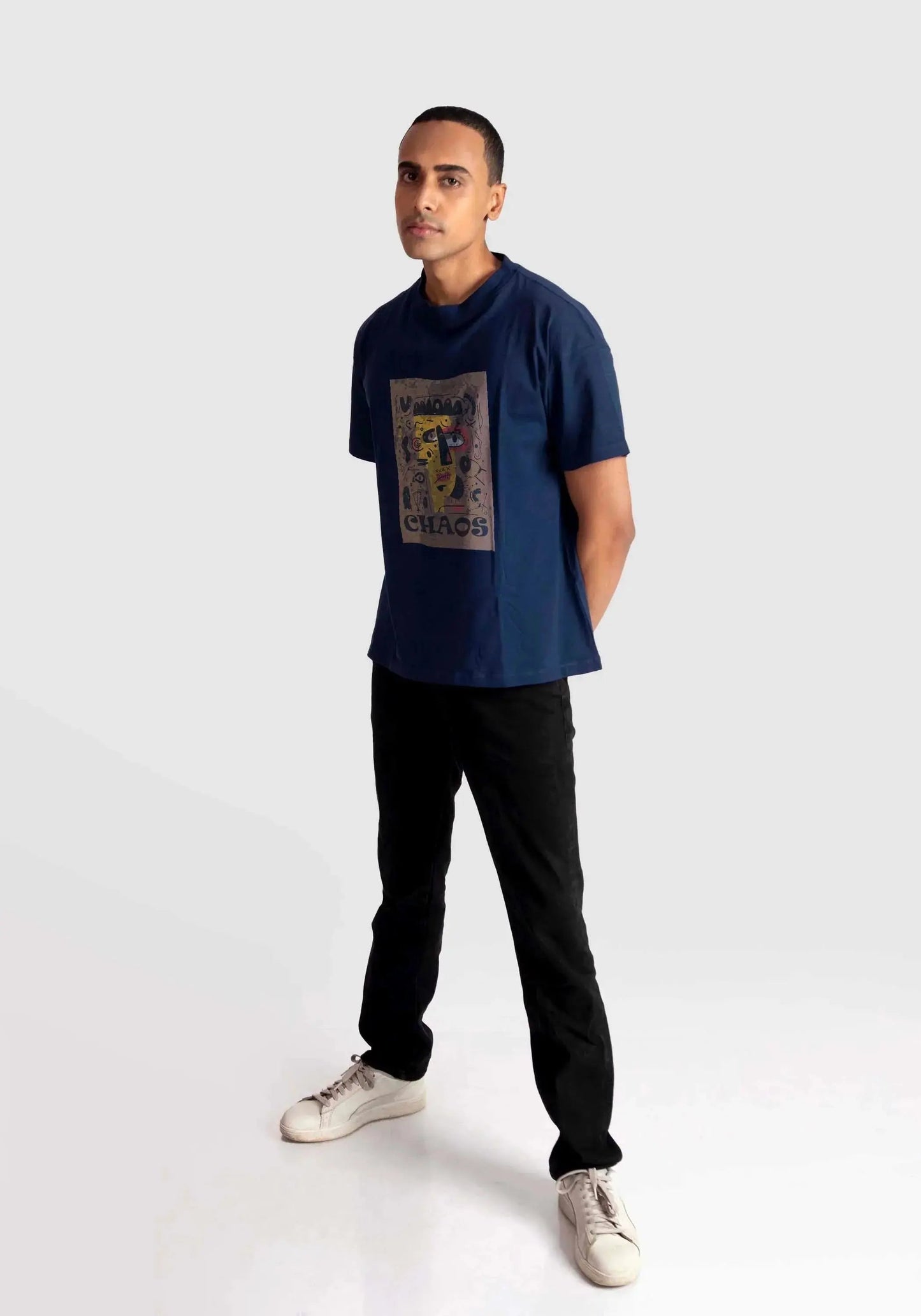 Man wearing a navy regular fit art print t-shirt by Stylera paired with black pants and white sneakers