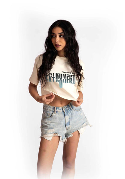Woman wearing a white oversized crop fit tee with graphic print and distressed denim shorts