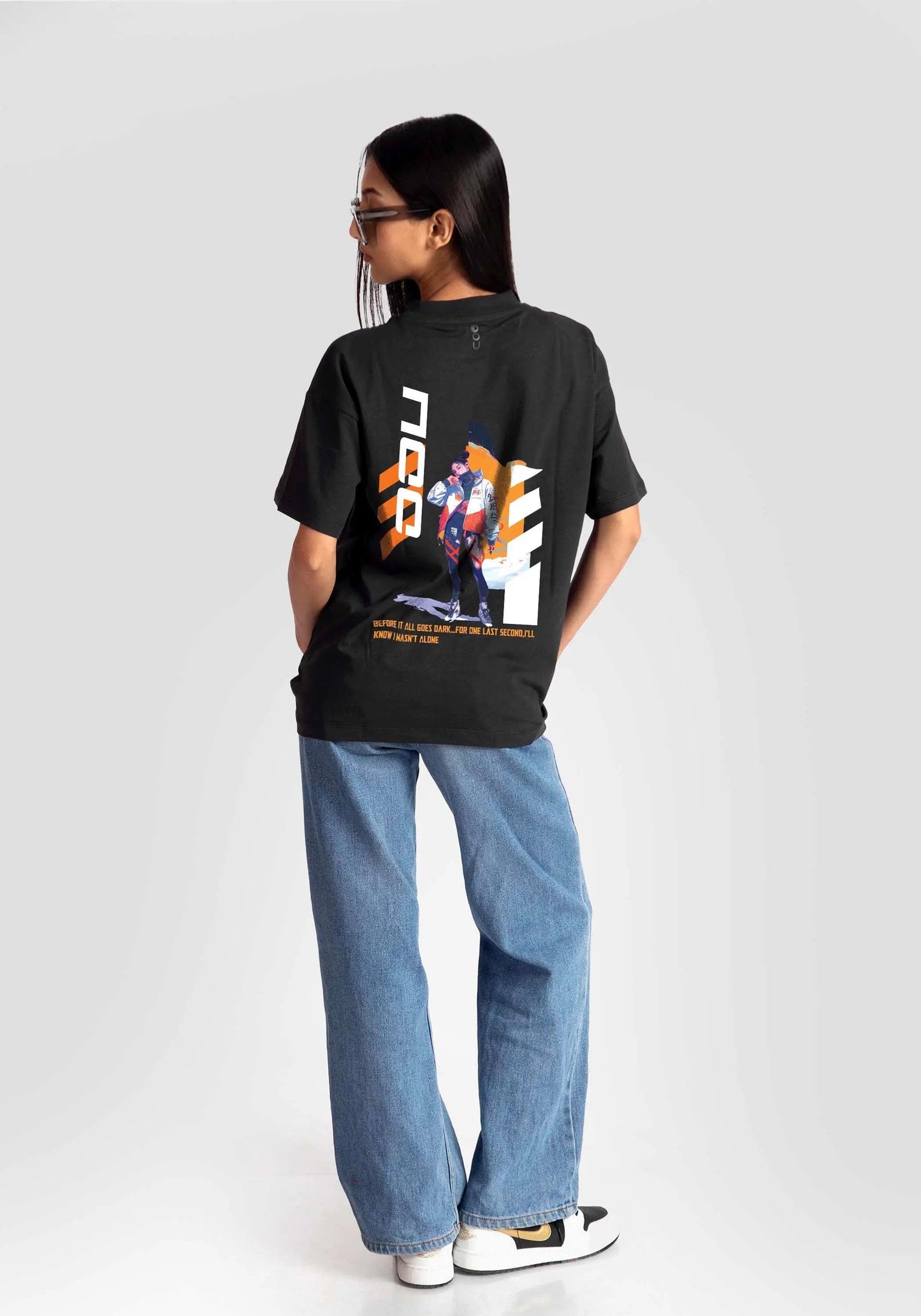 Black streetwear oversized tee womens by Stylera with graphic print on back paired with blue jeans
