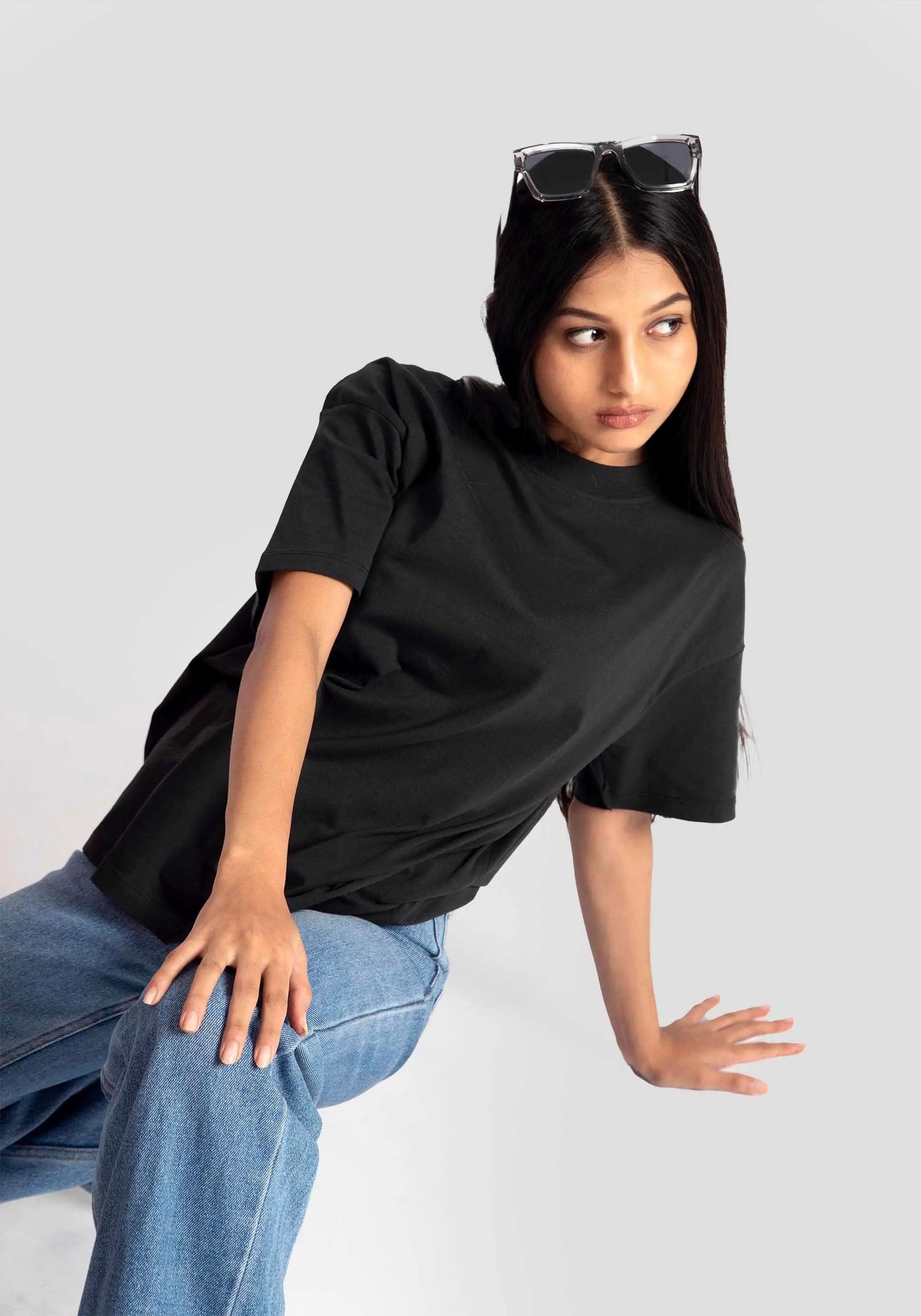 Stylera black streetwear oversized tee womens styled with blue jeans and sunglasses