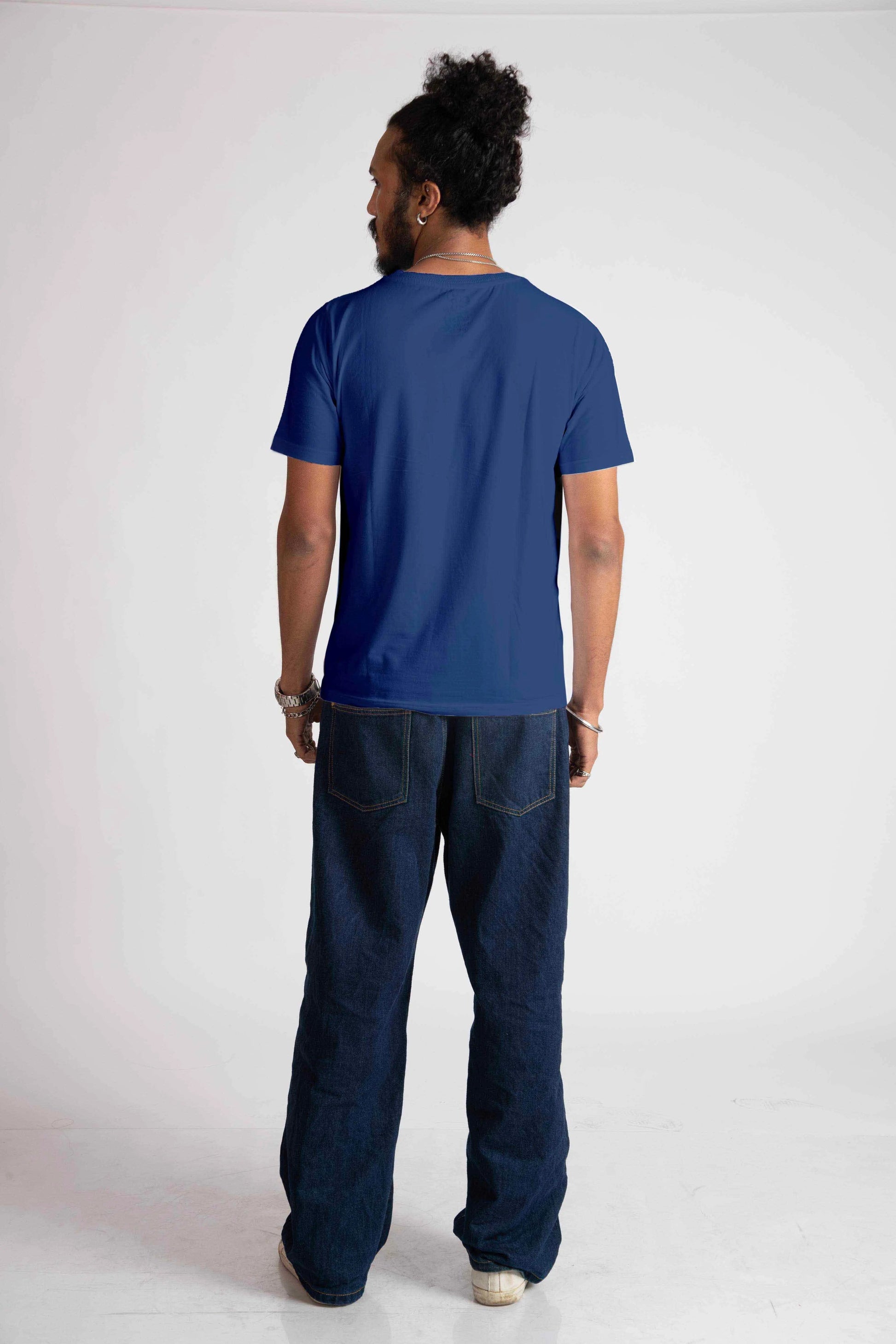 Back view of man wearing blue jacquard regular fit t-shirt paired with dark jeans