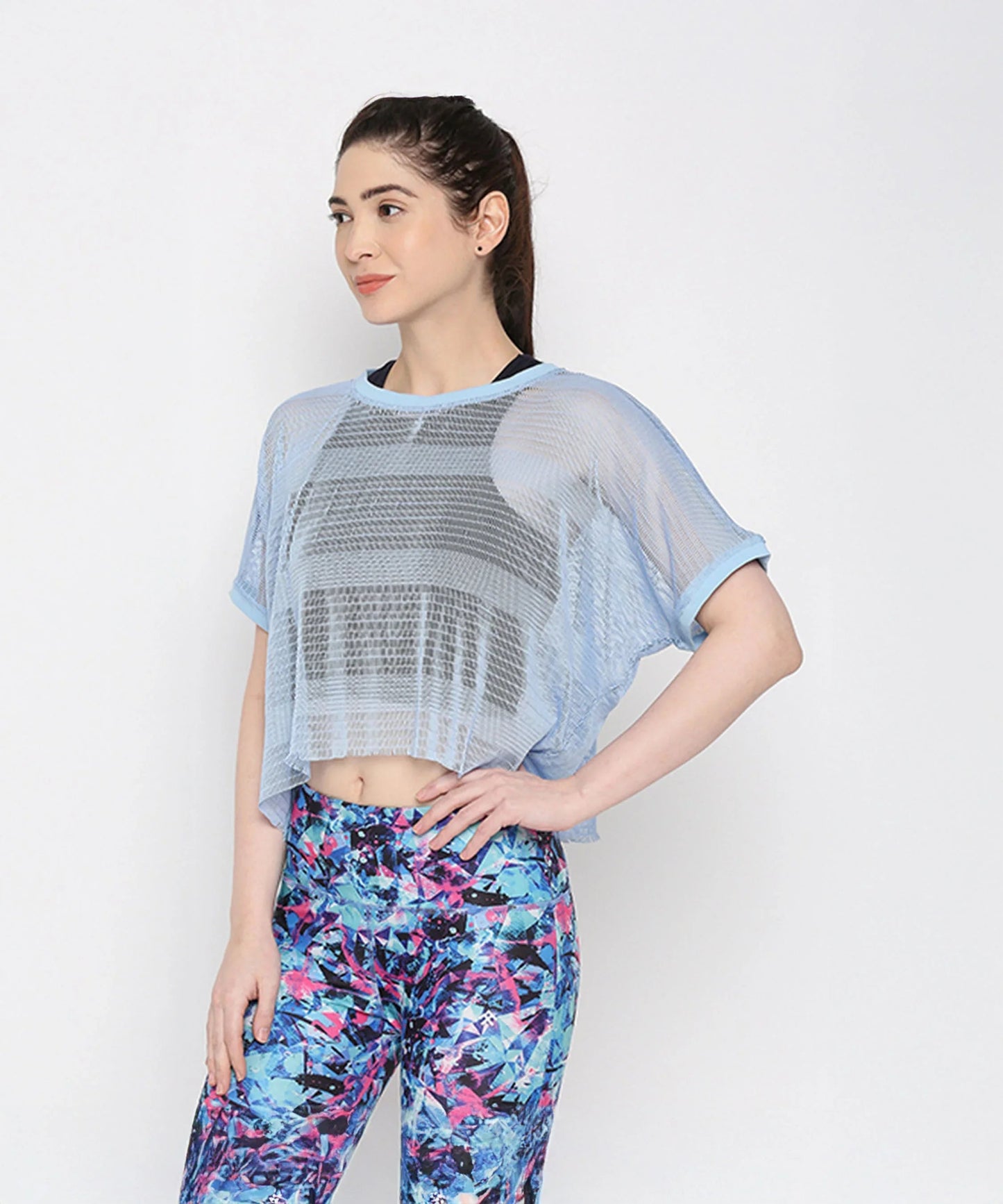 Light blue netted top for women featuring a loose fit and paired with colorful leggings