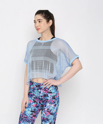Light blue netted top for women featuring a loose fit and paired with colorful leggings