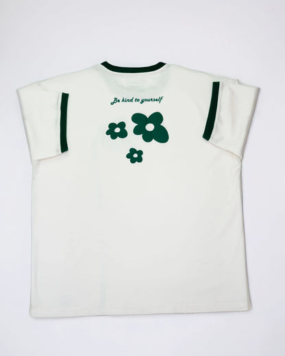 Cream oversized flower t-shirt featuring green flower graphics and a kindness message on the back