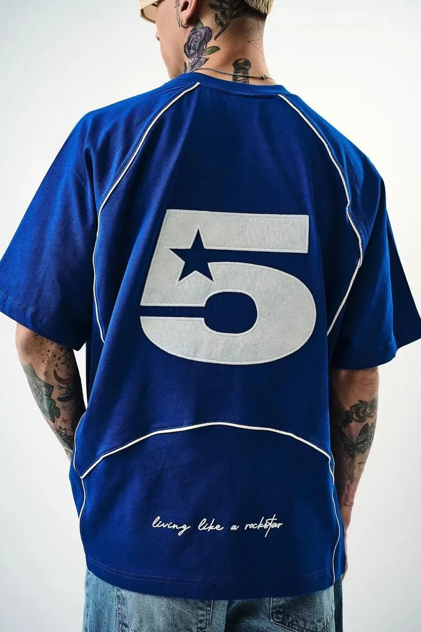Person wearing a blue sports jersey with the number 5 on the back, standing against a white background.