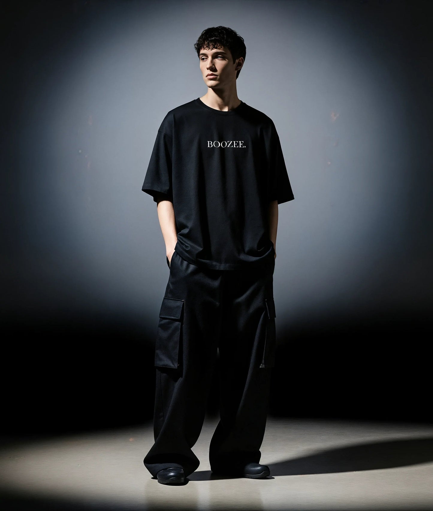 Person wearing a black 'BOOZEE' t-shirt and pants against a dark background