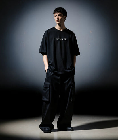 Person wearing a black 'BOOZEE' t-shirt and pants against a dark background