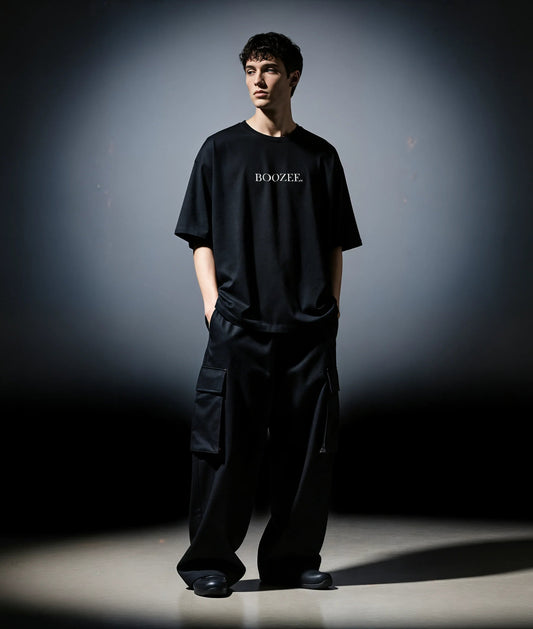 Person wearing a black 'BOOZEE' t-shirt and pants against a dark background