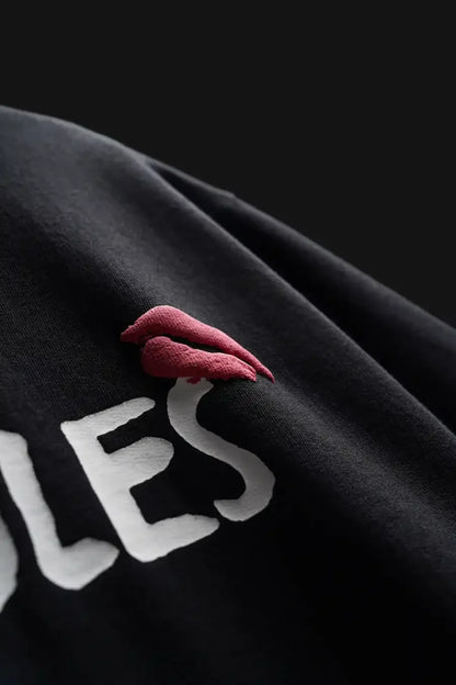 Black sweatshirt with red lips and white text on a dark background