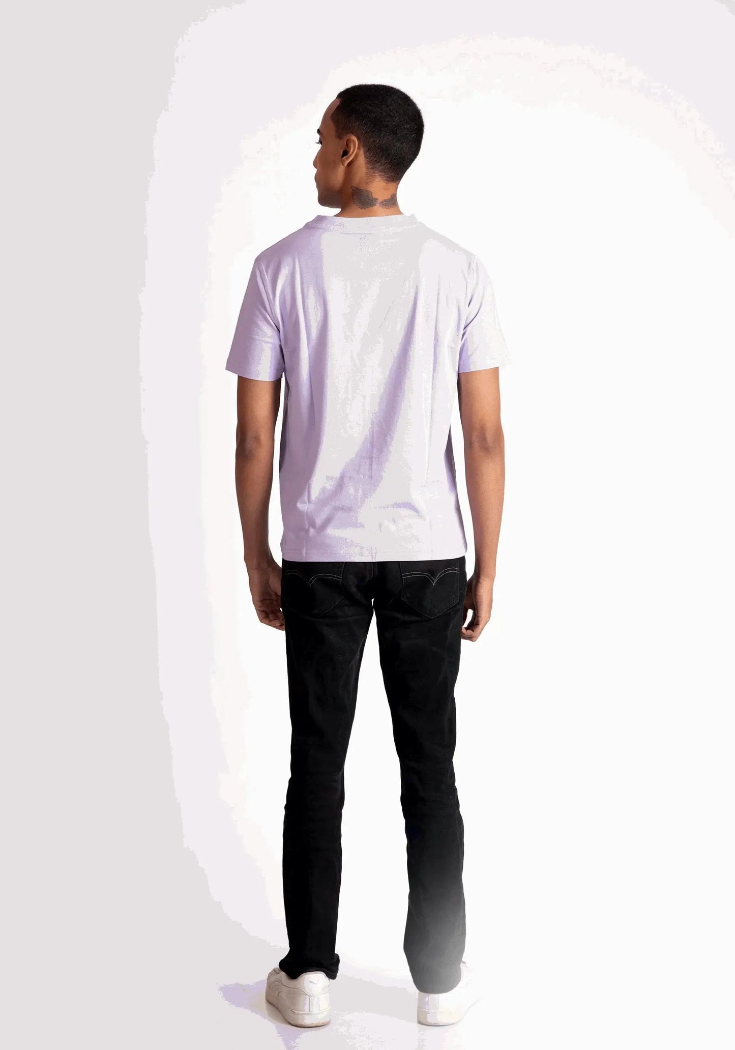Back view of a man wearing a lavender t-shirt for men paired with black pants and white sneakers