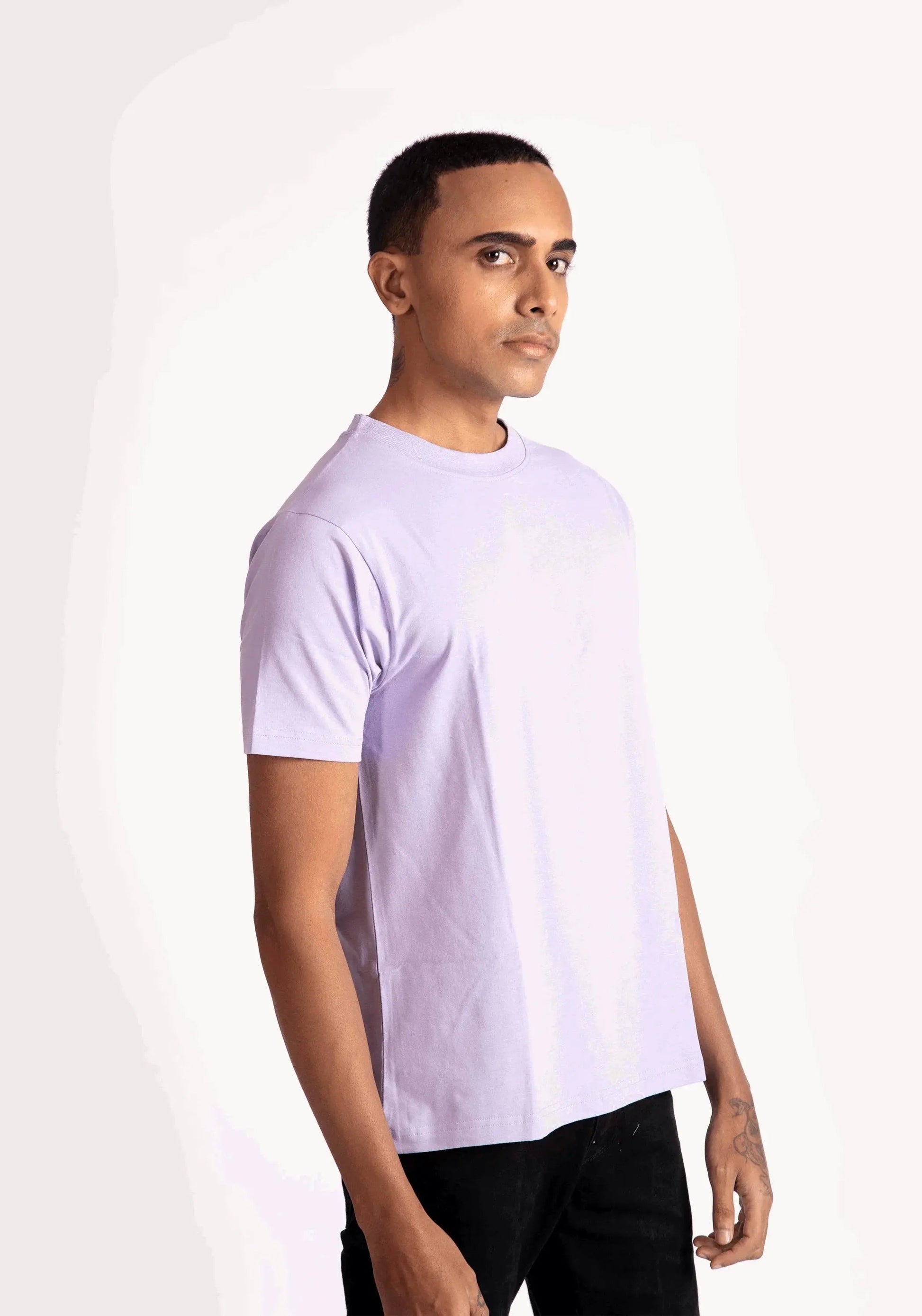 Stylera lavender t-shirt for men worn by model in casual black pants on white background