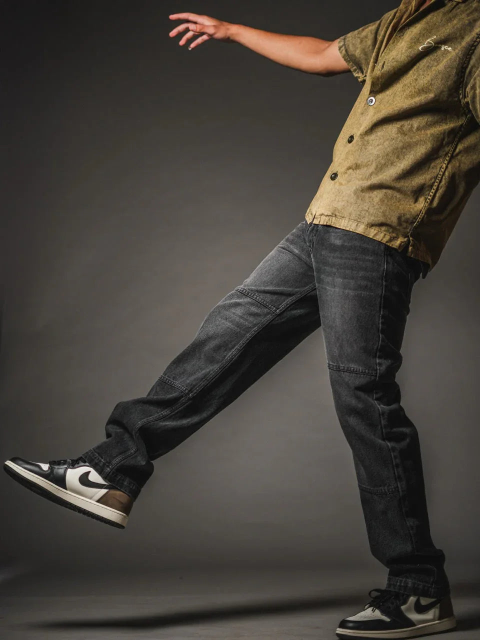 Front view of black loose fit jeans with knee panel detail for men.