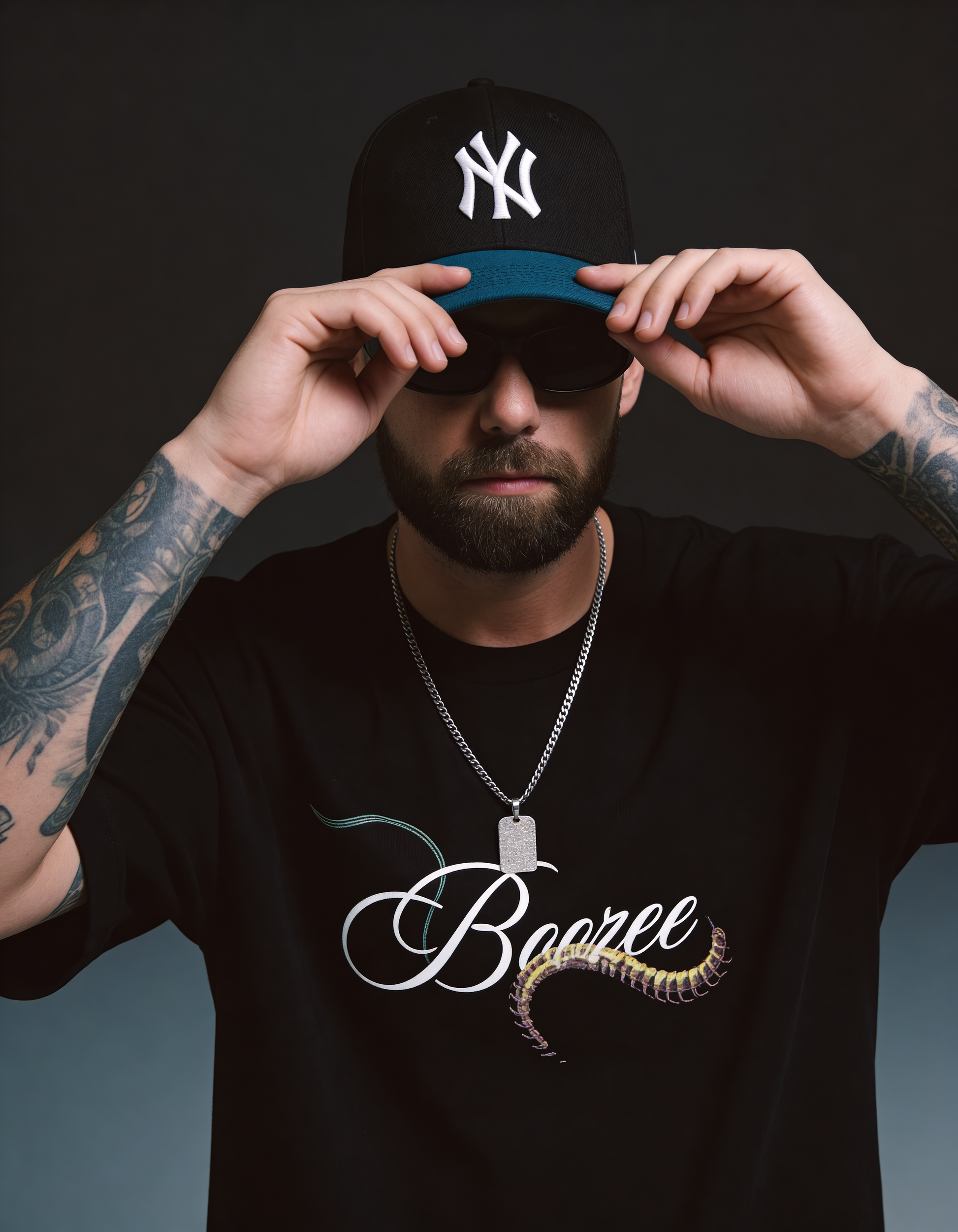 Man wearing a black cap with a logo, sunglasses, and a black t-shirt with 'Boozee' design.