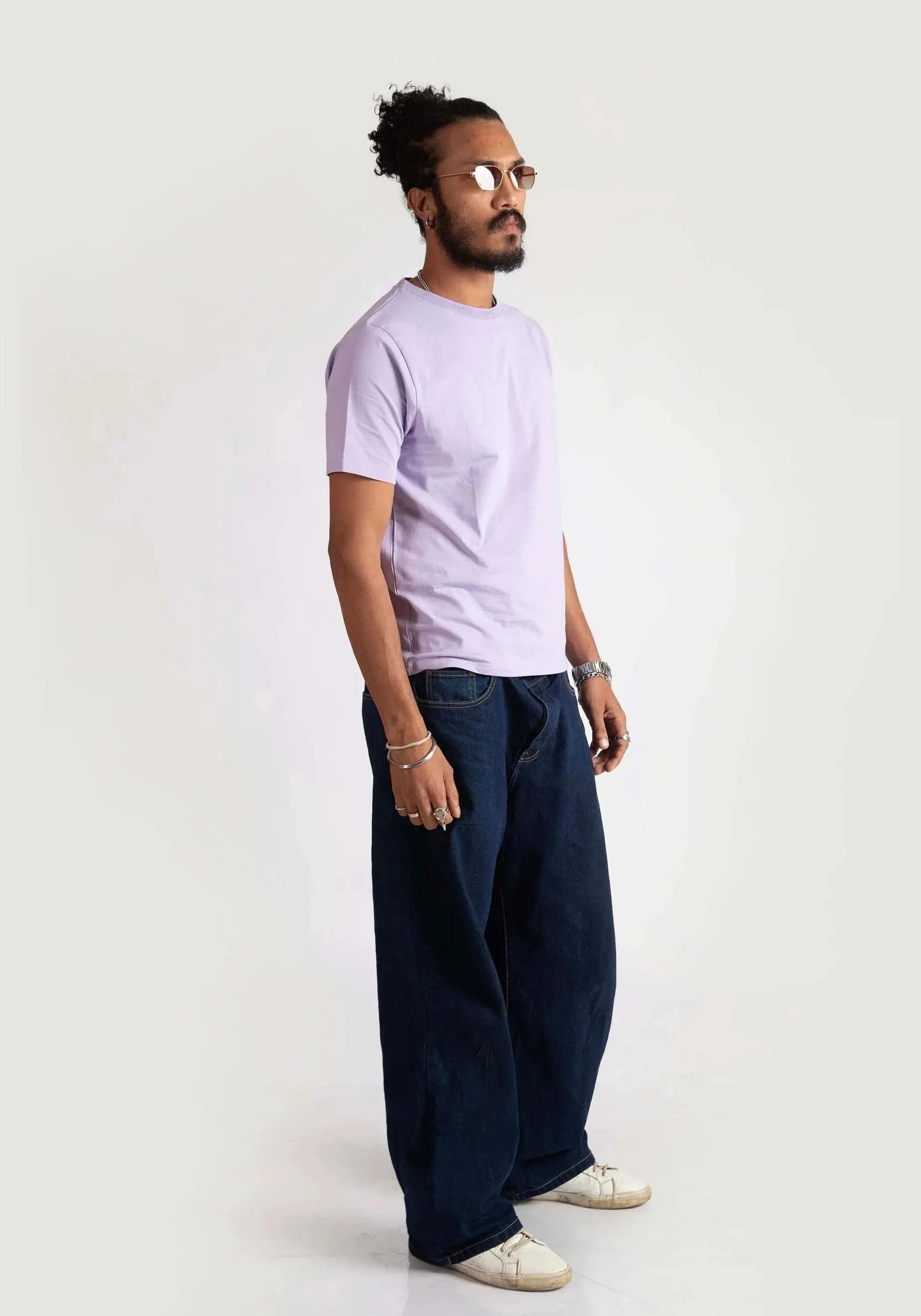 Model wearing Stylera men's regular fit lavender tee paired with dark wide-leg pants and white sneakers