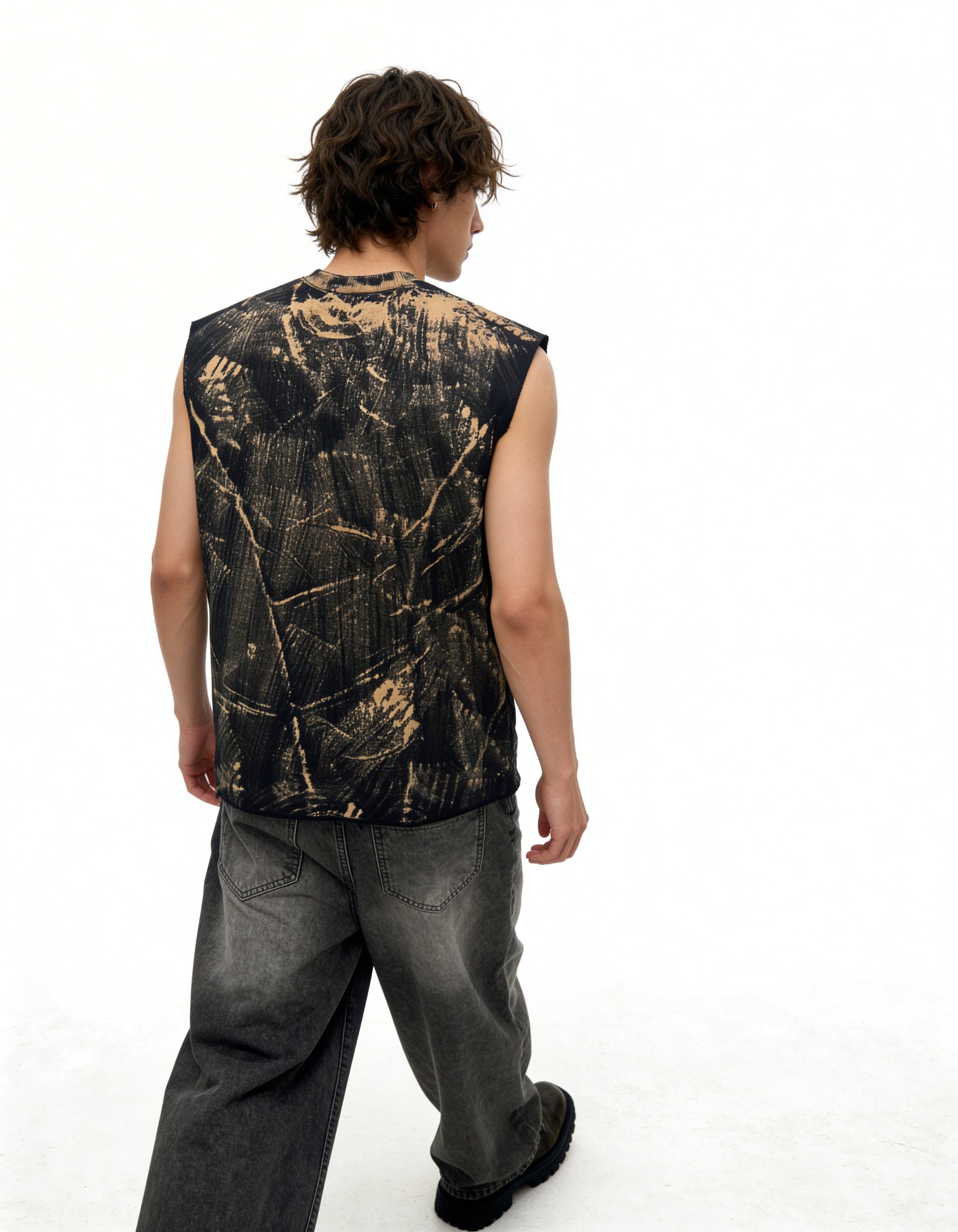 Person wearing a sleeveless black and gold patterned shirt on a white background
