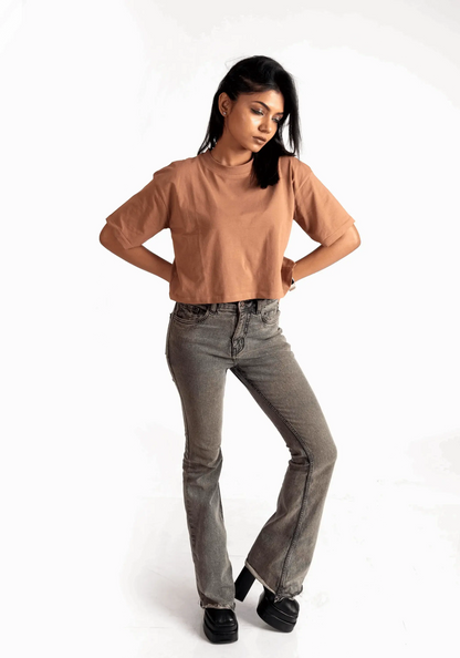 Woman wearing mocha oversized crop top from Stylera paired with gray jeans and black shoes