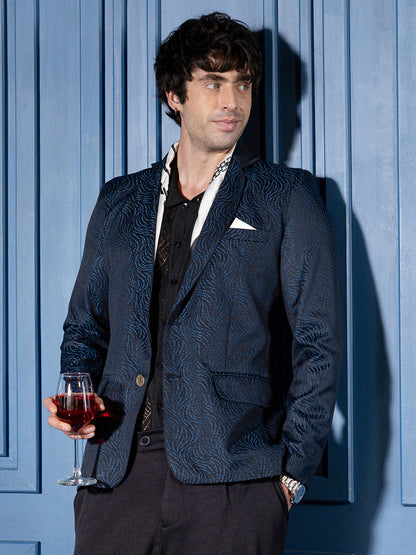 Man wearing a navy blue tailored blazer with an abstract streak jacquard pattern.