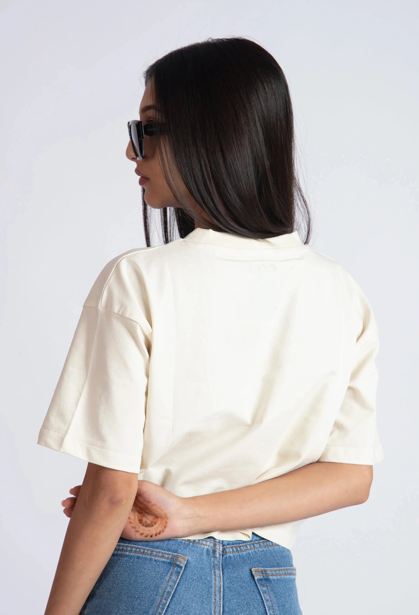 Stylera oversized crop top for women in cream color worn with blue jeans and sunglasses