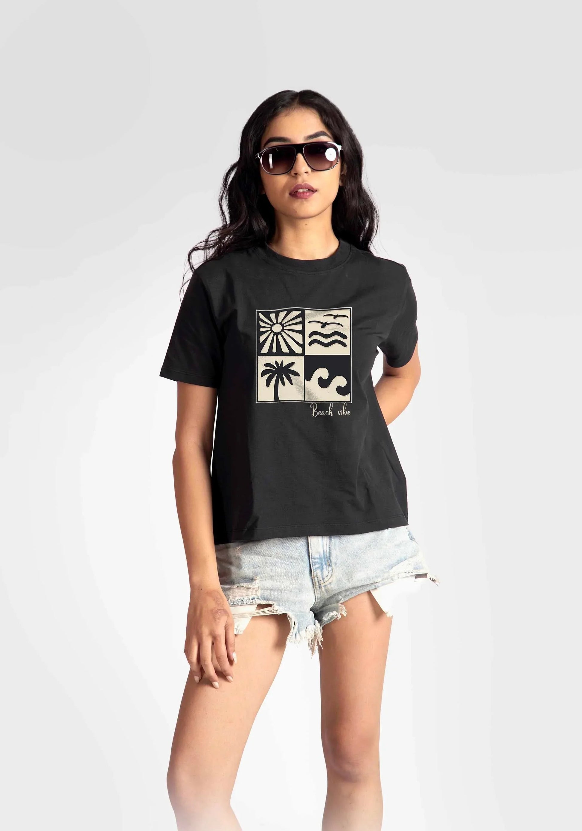 Stylera regular fit black t-shirt for women with graphic beach print worn with denim shorts