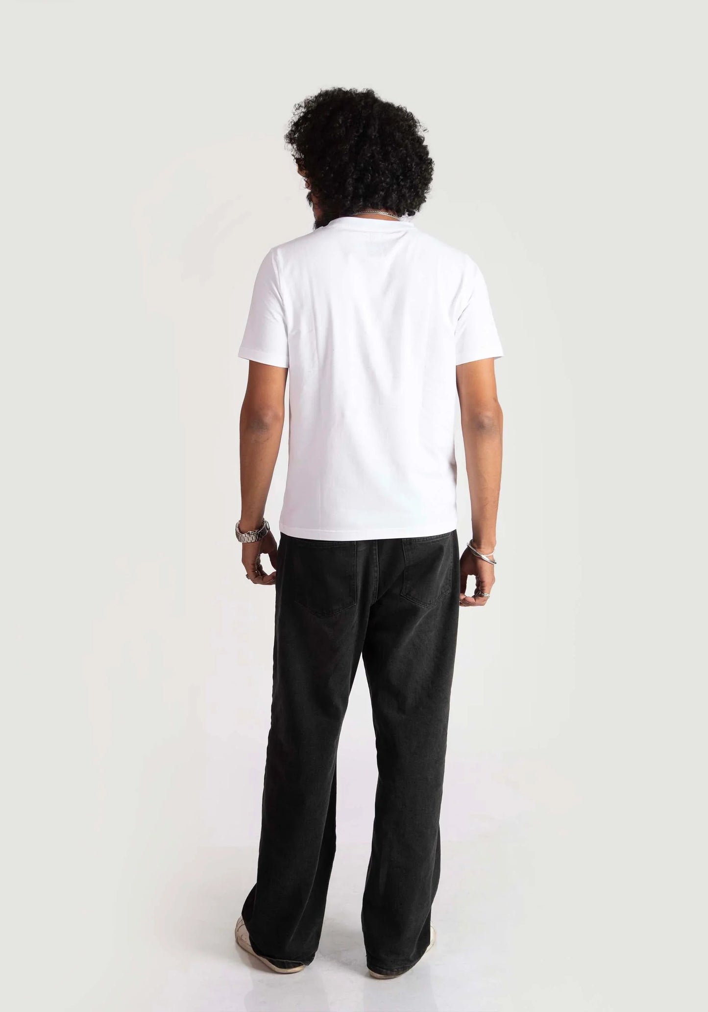 Back view of a person wearing Stylera regular fit white tee paired with black pants