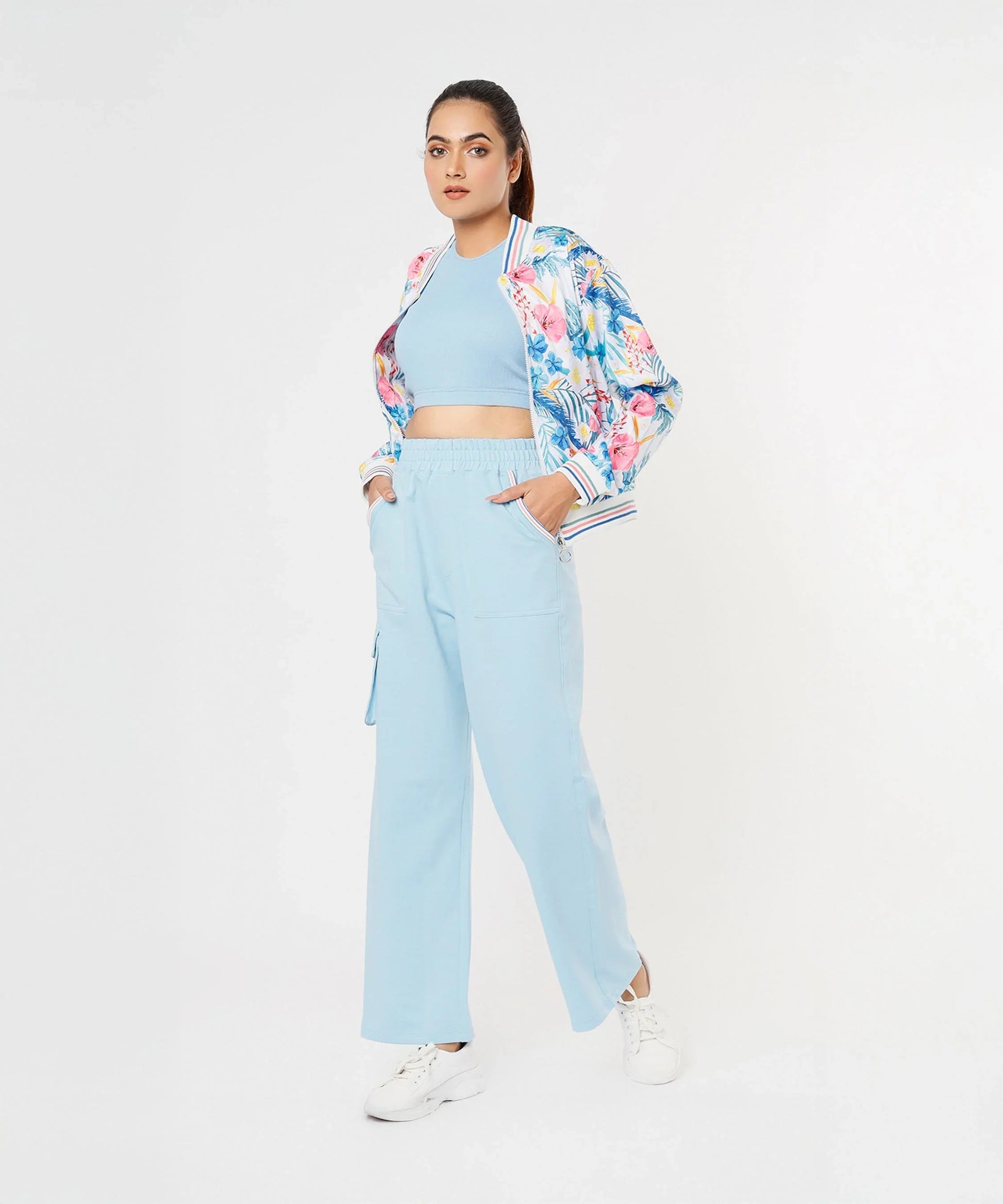 Trendy model wearing stylish co ord sets for women, featuring a floral bomber jacket and light blue pants