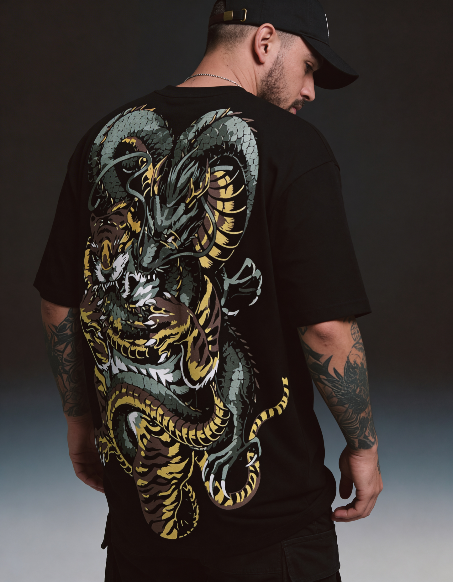 Man wearing a black t-shirt with a large dragon design on the back.