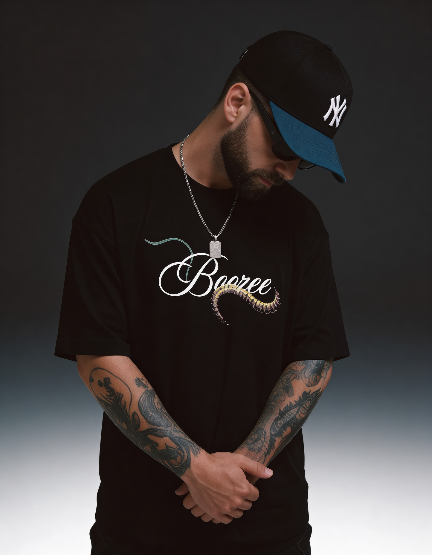 Man wearing a black t-shirt with 'Baane' design and a cap on a gradient background